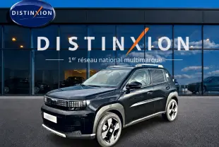 Vue 3/4 avant droite d'une FIAT Grande Panda 1.2 hybrid noire avec jantes alu 17 et barres de toit visibles devant un showroom Distinxion.