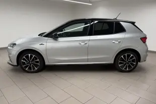 Vue de profil côté gauche d'une Skoda Fabia 2025 gris argent avec toit noir et jantes noires à motifs argentés.