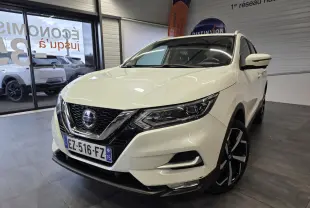 Nissan Qashqai blanc vue 3/4 avant droit en intérieur, avec jantes alliage noires et calandre chromée.