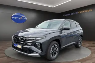 Hyundai Tucson 1.6 Hybrid gris foncé en 3/4 avant droit, avec calandre large et jantes alliage distinctives.