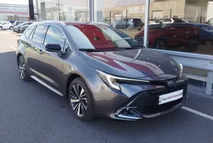 Toyota Corolla Touring Sport gris Atlas vue 3/4 avant droit, mettant en valeur sa calandre large et ses jantes alliage.