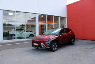Hyundai Kona hybride rouge Ultimate métal vu en 3/4 avant droit, avec toit noir et jantes bi-ton.