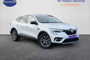 Renault Arkana blanc en 3/4 avant droit, avec calandre noire et jantes alliage gris foncé visibles.