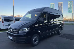 Profil latéral gauche d'un Volkswagen Crafter Van noir intense 2025, version longue et haute, sans fenêtres latérales arrière.