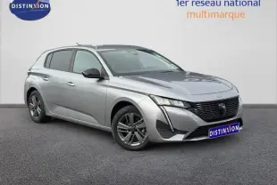 Peugeot 308 gris Artense vue 3/4 avant droit, avec calandre noire distinctive et jantes alliage foncé.