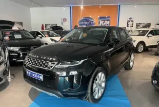 Range Rover Evoque noir Santorini vu en 3/4 avant droit dans un showroom avec sol bleu et autres véhicules autour.
