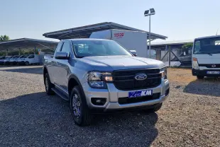 Ford Ranger Super Cabine gris iconic en 3/4 avant droit, avec calandre noire et plaque Zero KM visible.
