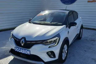 Renault Captur E-Tech blanc nacré avec toit noir, vue 3/4 avant droit, calandre noire et phares LED allumés.