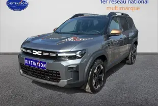 Vue 3/4 avant d’un Dacia Bigster gris schiste avec rétroviseurs bronze et jantes noires sur fond neutre.