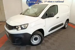 Vue 3/4 avant droit d’un Peugeot Partner blanc 2022 avec pare-chocs noirs et jantes acier en intérieur showroom.