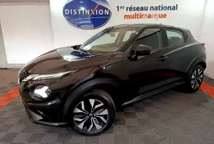 Nissan Juke noir en vue 3/4 avant droit, avec jantes alliage bicolores et phares LED ellipsoïdaux visibles.