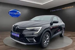 Renault Arkana noir en 3/4 avant droit, avec phares LED allumés et jantes alliage visibles en showroom.