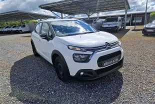 Citroën C3 Société blanc vue 3/4 avant droit, avec calandre noire et feux LED distinctifs, sur parking extérieur.