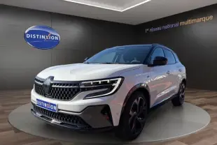 Vue 3/4 avant d’un Renault Austral blanc avec calandre noire et jantes noires dans un showroom.