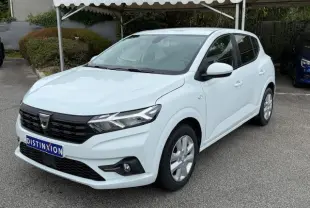 Dacia Sandero 2023 blanc glacier vue 3/4 avant droit, calandre noire et jantes alliage argentées visibles.