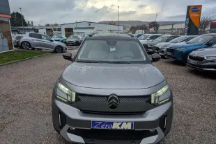 Citroën C3 Aircross gris métallisé vue de face avec toit noir et phares LED allumés sous la pluie.