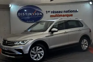 Volkswagen Tiguan gris clair vu de profil droit en intérieur avec jantes alliage et toit ouvrant chromé.