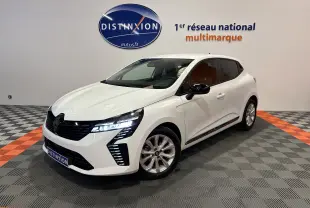 Renault Clio V blanche vue 3/4 avant droit avec feux LED allumés dans un showroom multimarque.