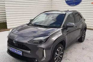 Toyota Yaris Cross gris atlas métal vue 3/4 avant droit, avec jantes alliage bicolores et toit noir brillant.