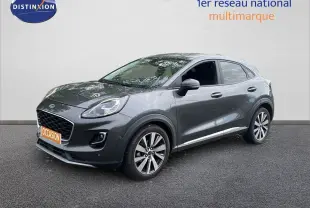 Ford Puma gris 3/4 avant droit, SUV compact avec jantes alliage et calandre noire distinctive.