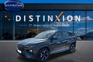 Hyundai Tucson 1.6 T-GDI hybride gris écotronique en 3/4 avant, avec jantes alliage 19 pouces et calandre glossy noire.