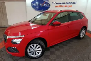 Vue 3/4 avant gauche d'un Skoda Kamiq rouge 2024 avec jantes alliage et barres de toit argentées.