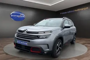 Citroën C5 Aircross gris acier en 3/4 avant droit, avec détails rouges sur le pare-chocs et jantes stylisées.