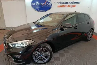 BMW Série 1 118i Edition Sport noire vue en 3/4 avant, phares LED allumés et jantes alliage distinctives.