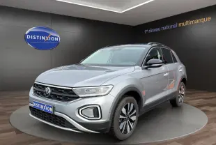 Volkswagen T-Roc gris clair en 3/4 avant droit, avec jantes alliage et calandre noire distinctive.