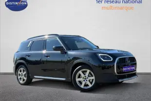 Mini Countryman D 163ch Favoured 2024 en Midnight Black II, vue 3/4 avant droit avec jantes argentées distinctives.