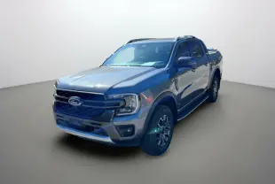 Ford Ranger 2026 gris carbone en 3/4 avant droit avec jantes alu 18 pouces et barres de toit visibles.