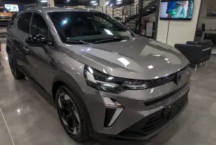 Renault Captur 2025 gris Cassiopé en 3/4 avant droit, avec calandre moderne et jantes noires bicolores.