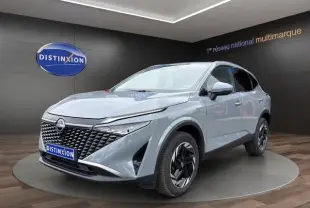 Vue 3/4 avant d’un Nissan Qashqai gris foncé exposé en showroom avec calandre noire et jantes stylisées.