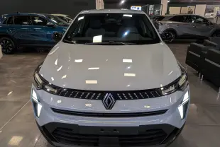 Vue frontale du Renault Captur 2025 gris rafale avec feux LED allumés dans un showroom.