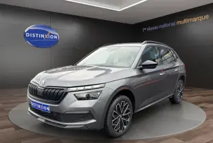 Skoda Kamiq gris foncé en 3/4 avant droit avec jantes bi-ton et calandre noire brillante dans showroom.
