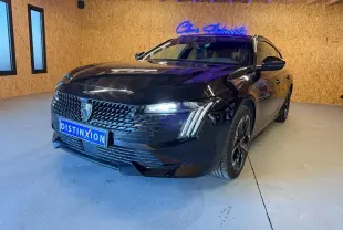 Peugeot 508 SW noire vue 3/4 avant droit avec calandre noire brillante et feux LED allumés en intérieur.
