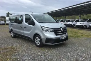Renault Trafic Combi gris clair métal vu en 3/4 avant droit, avec calandre chromée et grandes vitres latérales.