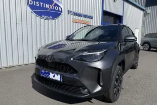 Toyota Yaris Cross 1.5 Hybrid gris atlas métal vue 3/4 avant avec calandre noire et jantes foncées.