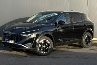 Nissan Qashqai noir Kuro en 3/4 avant droit, avec jantes alliage noires et calandre distinctive brillante.