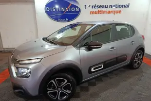 Vue 3/4 avant droite d'une Citroën C3 2024 gris clair avec protections latérales noires et jantes noires à inserts argentés.