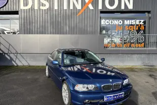 BMW Série 3 Coupé E46 330CI bleu en 3/4 avant droit, avec jantes alliage 18 pouces et phares LED visibles.