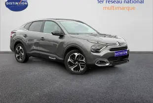 Vue 3/4 avant droite d'une Citroën C4 X gris 2024 avec signature lumineuse distinctive et jantes noires bicolores.
