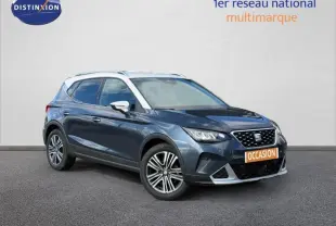 SEAT Arona 2025 bleu saphir métal avec toit blanc vu en 3/4 avant, mettant en valeur ses jantes et calandre distinctive.
