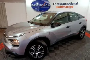 Vue 3/4 avant droite d'une Citroën C4 gris foncé avec phares allumés et jantes alliage distinctives.