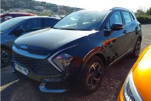 KIA SPORTAGE noir en 3/4 avant droit, mettant en valeur sa calandre distinctive et ses phares LED angulaires.