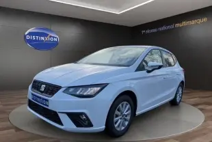 Vue 3/4 avant droite d'une SEAT Ibiza blanche 2023 avec vitres arrière surteintées et feux LED, en showroom.