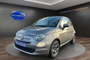 Vue 3/4 avant d'une FIAT 500 gris foncé avec jantes distinctives et phares ronds dans un showroom.