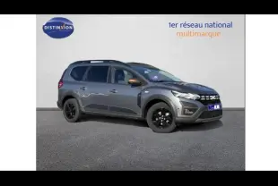 Vue 3/4 avant droit d'un Dacia Jogger gris schiste métallisé avec jantes noires et barres de toit.