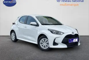 Toyota Yaris 116h Dynamic blanc lunaire vue 3/4 avant droit avec calandre noire et jantes acier.