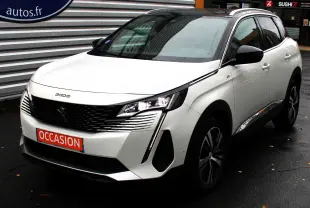 Peugeot 3008 blanc nacré en 3/4 avant droit, avec toit panoramique noir et feux LED allumés sur sol humide.